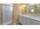 Bathroom featuring double sinks, marble counters, and tiled walk-in shower with glass enclosure at 612 Fern St, Anna Maria, FL 34216