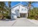 Charming coastal home with light blue shutters and lush tropical landscaping at 612 Fern St, Anna Maria, FL 34216