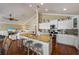 Kitchen island with counter seating, white cabinets, stainless appliances, and granite counters at 612 Fern St, Anna Maria, FL 34216