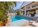 Backyard with a pool, lounge chairs, tropical landscaping, and a two-story home at 612 Fern St, Anna Maria, FL 34216
