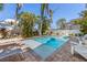 A beautiful backyard oasis with a sparkling pool, palm trees, and lounge chairs at 612 Fern St, Anna Maria, FL 34216