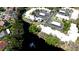 Aerial view of the property nestled amongst lush greenery with water view and community parking spaces at 631 Woodlawn Dr, Bradenton, FL 34210