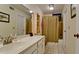 A clean bathroom with white vanity, tiled floor, and shower with decorative curtain at 631 Woodlawn Dr, Bradenton, FL 34210