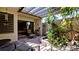 An inviting brick patio with pergola cover, seating, and lush tropical plants at 631 Woodlawn Dr, Bradenton, FL 34210