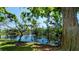 A picturesque pond with a fountain surrounded by lush trees and greenery at 631 Woodlawn Dr, Bradenton, FL 34210