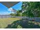 Expansive back yard is framed by a white picket fence and lush green trees under a beautiful blue sky at 6723 Trent Creek Dr, Sun City Center, FL 33573