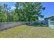 Large, fenced back yard featuring well-maintained grass and mature shade trees creating a serene outdoor space at 6723 Trent Creek Dr, Sun City Center, FL 33573