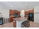 Well-lit kitchen with tile flooring, granite countertops, and a convenient island with seating at 6723 Trent Creek Dr, Sun City Center, FL 33573