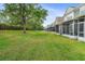 View of the backyard with a row of screened patios and lush green grass, perfect for outdoor activities at 7180 83Rd E Dr # 6-5, Bradenton, FL 34201