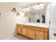 Bathroom featuring double sinks, wooden cabinets, and decorative wall shelves at 7180 83Rd E Dr # 6-5, Bradenton, FL 34201