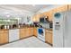 Bright kitchen with white appliances, wood cabinets, granite counters, and an open view to the living area at 7180 83Rd E Dr # 6-5, Bradenton, FL 34201