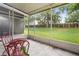 Screened patio area with red metal chairs and table overlooking a well-maintained lawn and greenery at 7180 83Rd E Dr # 6-5, Bradenton, FL 34201