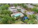 Aerial view of community pool with lounge chairs, and a playground, surrounded by lush greenery at 7180 83Rd E Dr # 6-5, Bradenton, FL 34201