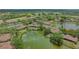 Beautiful aerial view of a villa in a golf community with mature trees and water features at 7269 Golf Pointe Way, Sarasota, FL 34243