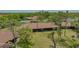 Aerial view of the home with a red tile roof, screened lanai, and surrounding greenery and community pool at 7269 Golf Pointe Way, Sarasota, FL 34243