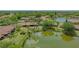 Wide aerial view showing the property near a pond, and neighboring homes at 7269 Golf Pointe Way, Sarasota, FL 34243