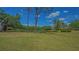 Expansive backyard with mature trees and views of a tranquil pond at 7269 Golf Pointe Way, Sarasota, FL 34243