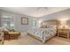 Charming bedroom with a light and airy feel showcasing a woven headboard and shuttered windows at 7269 Golf Pointe Way, Sarasota, FL 34243