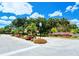 Landscaped community entrance featuring colorful flower beds and mature trees, welcoming residents and guests alike at 7269 Golf Pointe Way, Sarasota, FL 34243