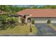 Well-maintained home exterior with a red tile roof, two-car garage, and well manicured lawn at 7269 Golf Pointe Way, Sarasota, FL 34243