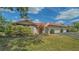 Charming townhome featuring a red tile roof and beautifully landscaped front yard at 7269 Golf Pointe Way, Sarasota, FL 34243