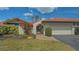 Lovely townhome with a red tile roof, brick-paved entrance, and green front lawn at 7269 Golf Pointe Way, Sarasota, FL 34243