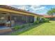 Back of home featuring a screened lanai, lush lawn, and meticulously maintained landscaping at 7269 Golf Pointe Way, Sarasota, FL 34243