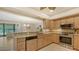 Well-lit kitchen boasts granite countertops, stainless appliances, and views of the dining area and water at 7269 Golf Pointe Way, Sarasota, FL 34243