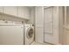 The laundry room is equipped with modern washer and dryer, and extra storage cabinets at 7269 Golf Pointe Way, Sarasota, FL 34243