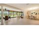 Bright sunroom boasts neutral decor, ceiling fan and panoramic views of the lush backyard at 7269 Golf Pointe Way, Sarasota, FL 34243