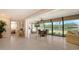 Open living room boasts tile flooring, floor to ceiling windows, and a view of the water at 7269 Golf Pointe Way, Sarasota, FL 34243