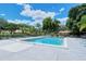 Sparkling community pool featuring lounge chairs, lush greenery, and a secure fence for privacy and relaxation at 7269 Golf Pointe Way, Sarasota, FL 34243