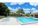 Community pool area featuring comfortable lounge seating, lush landscaping, and a clear blue swimming pool at 7269 Golf Pointe Way, Sarasota, FL 34243
