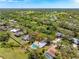 Aerial view of single-Gathering home with private pool nestled amidst lush trees and a sprawling green landscape at 7299 S Leewynn Dr, Sarasota, FL 34240