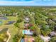 Property aerial view features a pool, lush greenery, and residential surroundings with a nearby lake at 7299 S Leewynn Dr, Sarasota, FL 34240