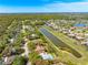 Aerial shot featuring a pool, serene lake nearby, and lush green neighborhood surroundings at 7299 S Leewynn Dr, Sarasota, FL 34240