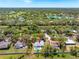 Expansive aerial shot of a beautiful home with a pool, enveloped by verdant trees and a picturesque neighborhood at 7299 S Leewynn Dr, Sarasota, FL 34240