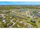 Serene aerial view of a home near a pond, surrounded by lush greenery and beautiful residential community at 7299 S Leewynn Dr, Sarasota, FL 34240