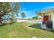 Expansive backyard featuring a lush green lawn, fenced pool, and a covered patio with a grill at 7299 S Leewynn Dr, Sarasota, FL 34240