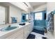 Bright bathroom with blue fixtures, a large mirror, and a well-lit vanity area at 7299 S Leewynn Dr, Sarasota, FL 34240