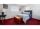Cozy bedroom with bright red carpet, wood accents, and natural light from windows at 7299 S Leewynn Dr, Sarasota, FL 34240