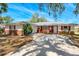 Charming home featuring a well-manicured lawn, brick accents, and a cozy front porch area at 7299 S Leewynn Dr, Sarasota, FL 34240