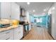 Well-lit kitchen with stainless appliances, white cabinets and modern tile backsplash at 7299 S Leewynn Dr, Sarasota, FL 34240