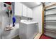 Laundry room with white washer and dryer, white cabinets, and utility sink, inside garage at 7299 S Leewynn Dr, Sarasota, FL 34240