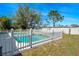 Swimming pool featuring clear blue water, surrounded by a white fence, and grassy yard at 7299 S Leewynn Dr, Sarasota, FL 34240
