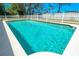 Swimming pool featuring clear blue water, a white concrete edge, and a white fence at 7299 S Leewynn Dr, Sarasota, FL 34240