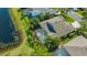 Aerial view of a home featuring a screened pool, patio area, and tropical landscaping near a pond at 7407 Green St, Bradenton, FL 34201