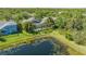 Aerial view of a home with a screened pool, surrounded by lush landscaping and near a pond at 7407 Green St, Bradenton, FL 34201