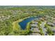 Scenic aerial view of a community with a large pond and a home with a screened pool at 7407 Green St, Bradenton, FL 34201