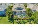 Beautiful aerial view of a home with a screened pool and lush landscaping in a tropical setting at 7407 Green St, Bradenton, FL 34201